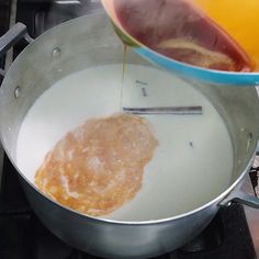 a pan filled with food cooking on top of a stove next to a frying pan