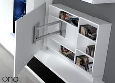 a white book shelf with several books on it's sides and an open door leading to another room