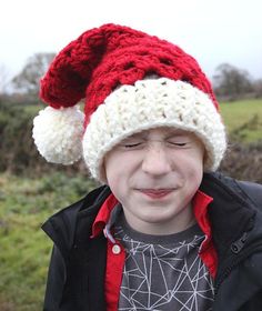 a young boy wearing a red and white knitted hat