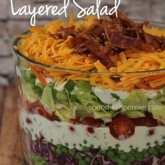 layered salad in a glass dish with bacon and cheese