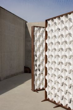 two large white sculptures sitting next to each other on top of a cement flooring area