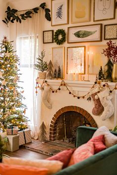 a living room with a christmas tree in the corner and pictures on the wall above it