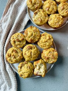 two plates with muffins on them next to a towel