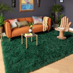 a living room filled with lots of furniture and decor on top of a green rug