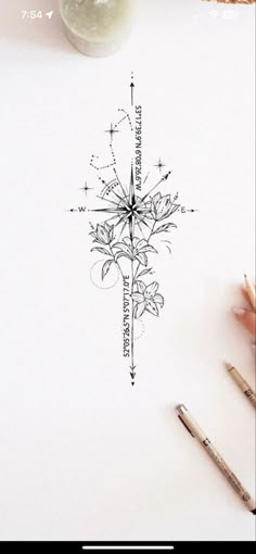 a drawing of a compass with flowers on it and some pencils next to it