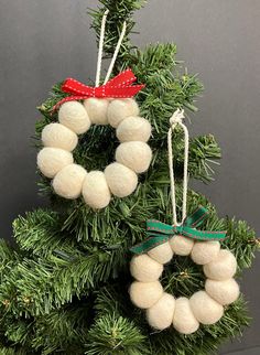 two ornaments are hanging from the top of a christmas tree