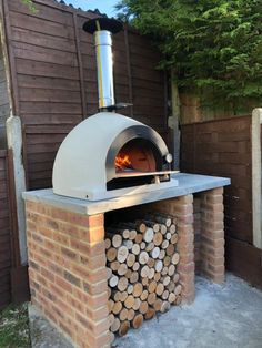 a brick oven with logs stacked in front of it