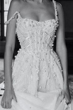 a black and white photo of a woman in a wedding dress with pearls on it