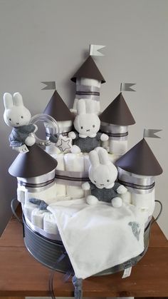 there is a cake made to look like a castle with bunnies on top and stuffed animals in the middle