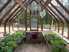 the inside of a greenhouse with lots of plants and flowers growing in pots on the ground