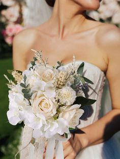 a woman holding a bouquet of flowers in her hands