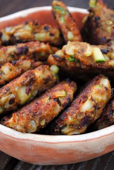 a bowl filled with fried food on top of a wooden table