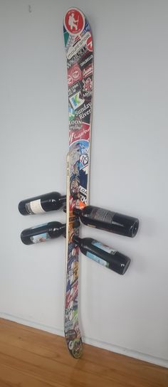 a pair of skis hanging from the side of a wall with stickers on it