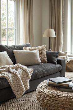 a living room filled with lots of furniture next to a large window covered in blankets