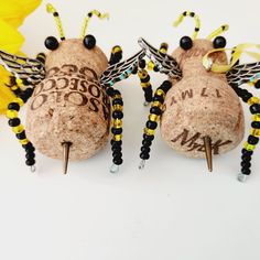 two corks with words written on them are sitting next to yellow flowers and beads