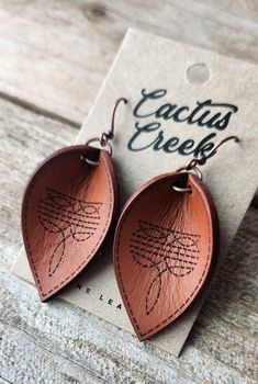 the leather earrings are shaped like leaves