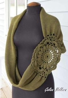 a mannequin wearing a green shawl with crochet on the side