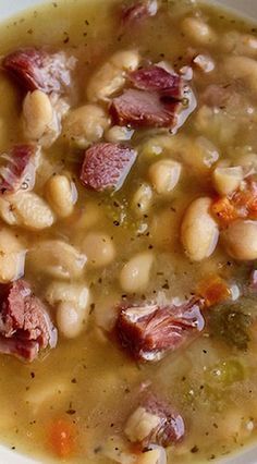 a white bowl filled with beans and ham