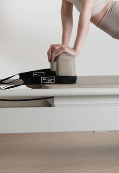 a woman bending over on top of a table with her leg in the air while holding onto an object