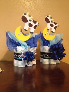 two baby shower items sitting on top of a wooden table