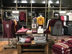 a store display with maroon and yellow shirts