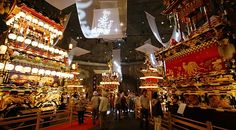 a group of people standing in a room with lots of decorations on the walls and ceiling