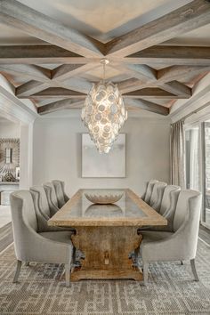 a dining room table with chairs and a chandelier hanging from the ceiling