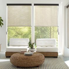 a living room with two couches and a coffee table in front of large windows