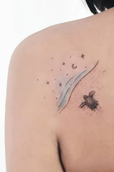 a woman's shoulder with a turtle and moon tattoo on her left side ribcage