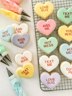 some cookies that are sitting on a cooling rack with markers and pens next to them