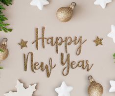 the words happy new year are spelled with gold and white ornaments on a beige background