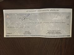 an old cheque check from the united states is on top of a wooden table