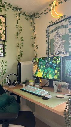 a computer desk topped with two monitors and a keyboard next to a plant covered wall