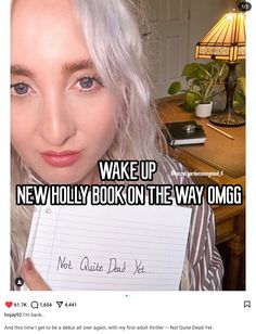 a woman holding up a note with the caption wake up new holly book on the way omg not quite dad yet