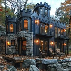 a large black house surrounded by trees and rocks