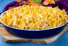 a casserole dish with macaroni and cheese in it on a wooden board