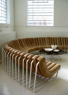 a curved couch sitting in the middle of a room