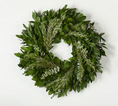 a wreath made out of green leaves and greenery