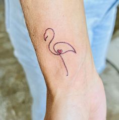 a small flamingo tattoo on the wrist