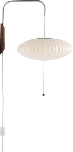 a white lamp hanging from the ceiling next to a wall mounted light fixture with a wooden frame