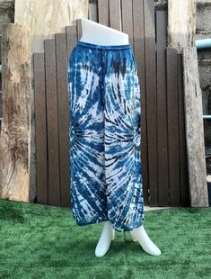 a mannequin wearing blue and white tie - dyed pants on display in front of a wooden fence