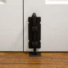 a black door handle on a white door with wood flooring in front of it