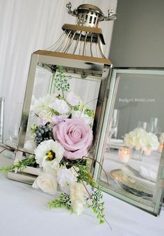 a table topped with two mirrors and flowers