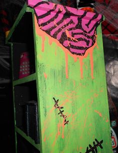 a green box with pink and black graffiti on it