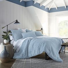 a bedroom with white walls and blue bedding