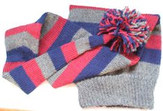 two knitted scarves with a pom - pom sitting on top of each other