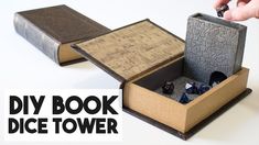 an open book sitting on top of a table next to a box filled with dice