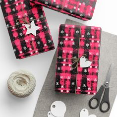 some wrapping paper and scissors are laying on the table next to yarn, twine and other crafting supplies