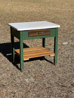 a green and white table sitting on top of a grass covered field