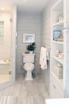 a white toilet sitting inside of a bathroom next to a walk in shower